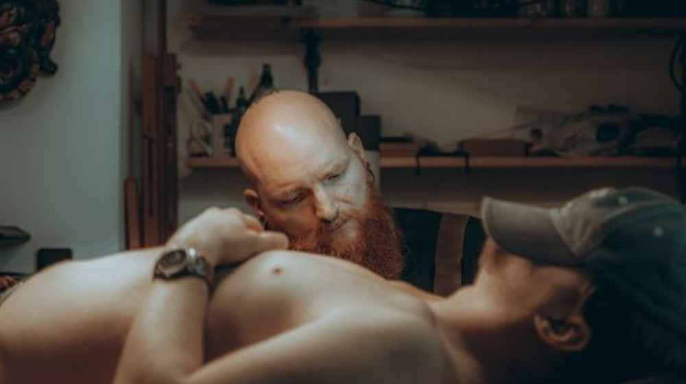 Isar tattooing Nordic sleeve on client