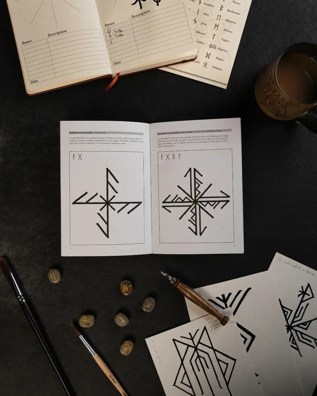Norse rune designs in art book with runestones, ink pen, and Viking-inspired sketching tools on dark surface