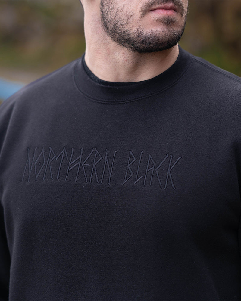 details of the black jumper with the northern black logo embroidered into it