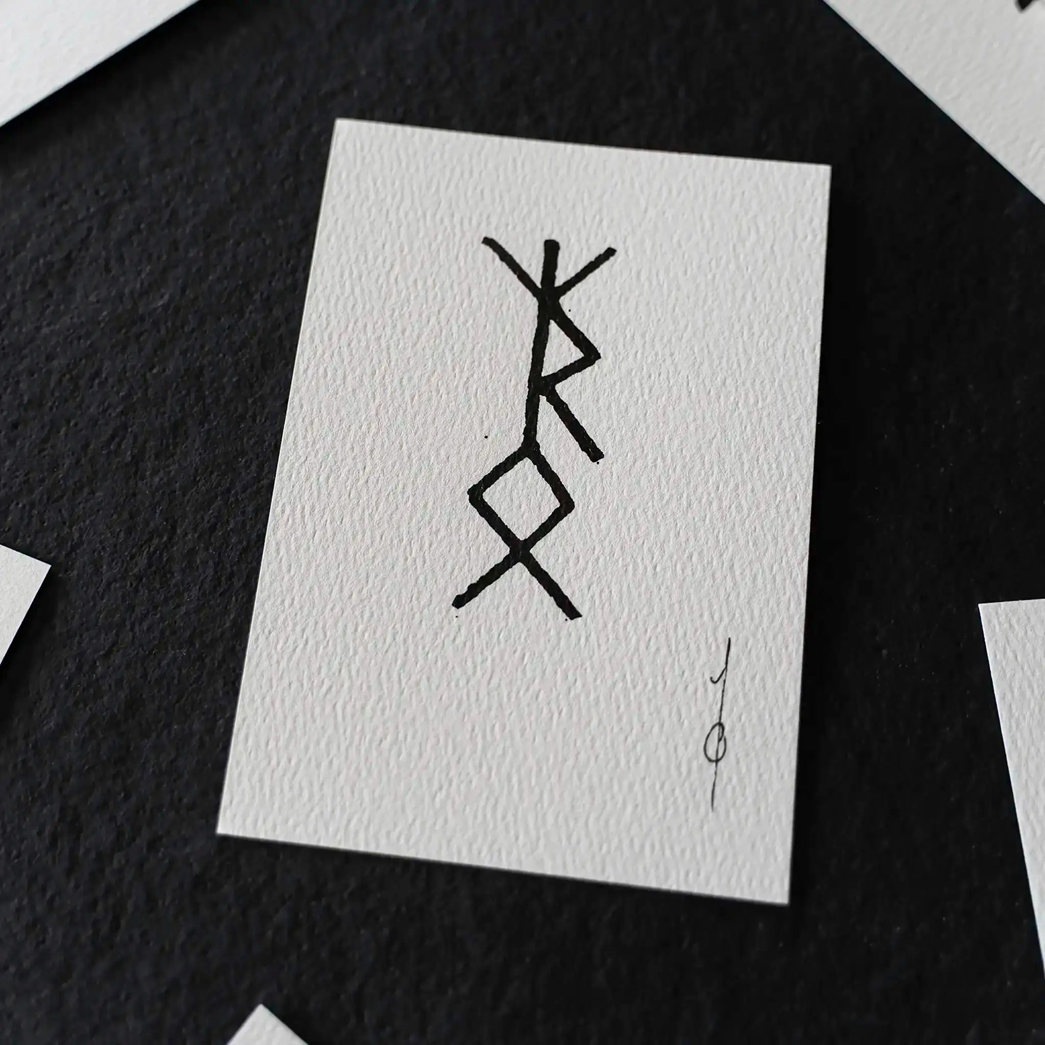 Hand-drawn Norse rune symbol on textured white card, inspired by Viking tattoo designs and ancient artifacts