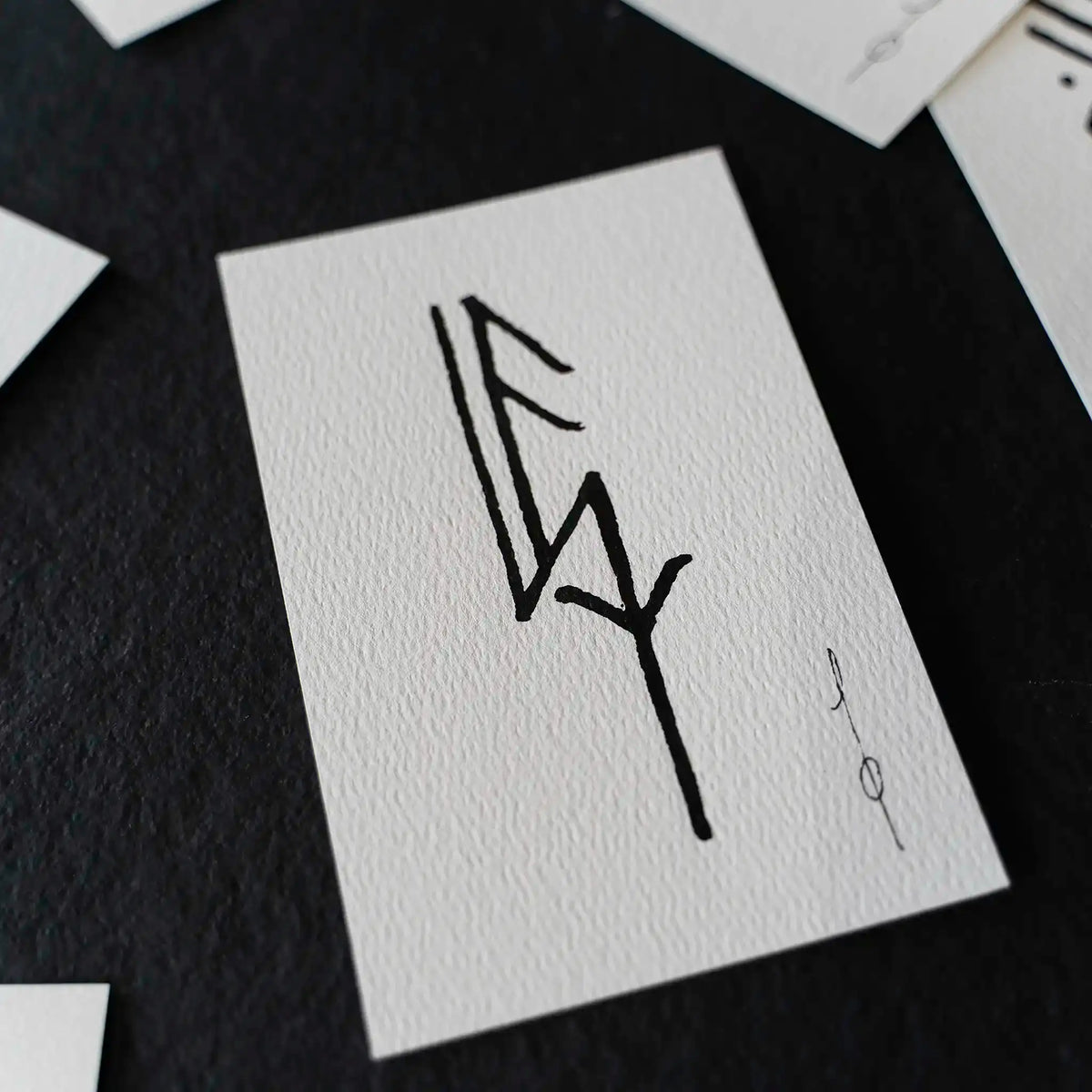 Hand-drawn Norse rune on textured white card, inspired by Viking tattoo designs and ancient artifacts