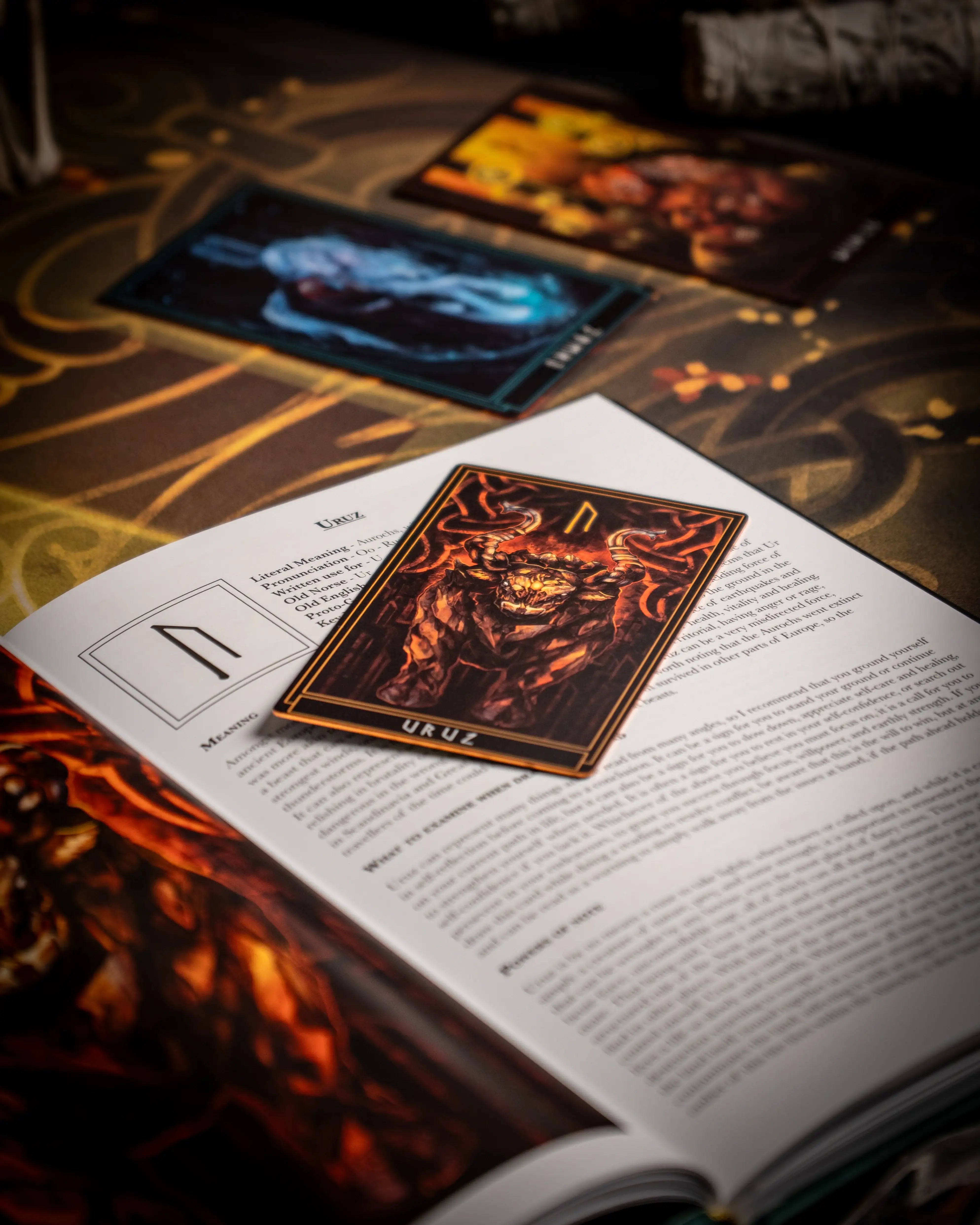 Viking rune card Uruz with fiery bull design, placed on Norse-themed book page