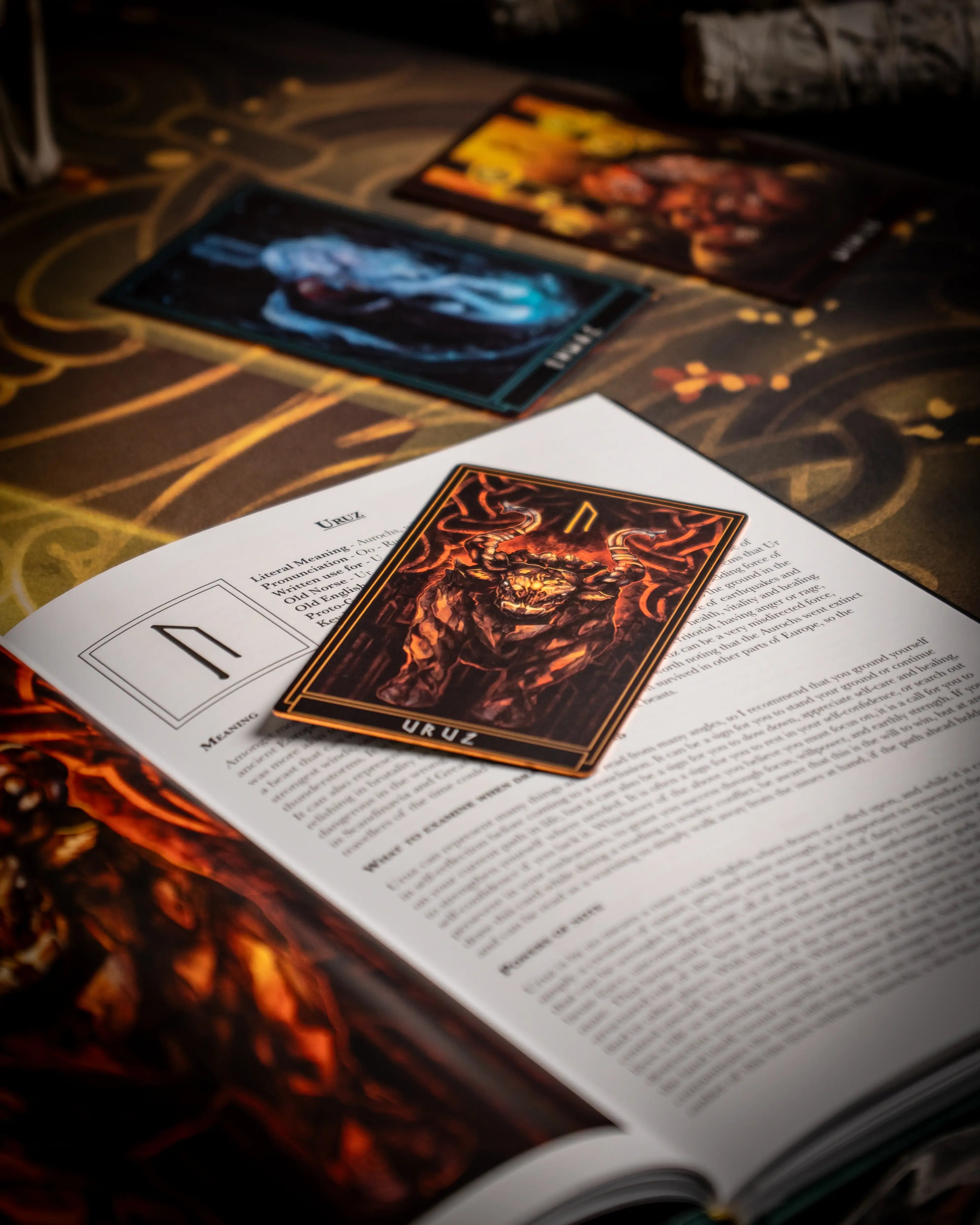 Viking rune card Uruz with fiery bull design, placed on Norse-themed book page