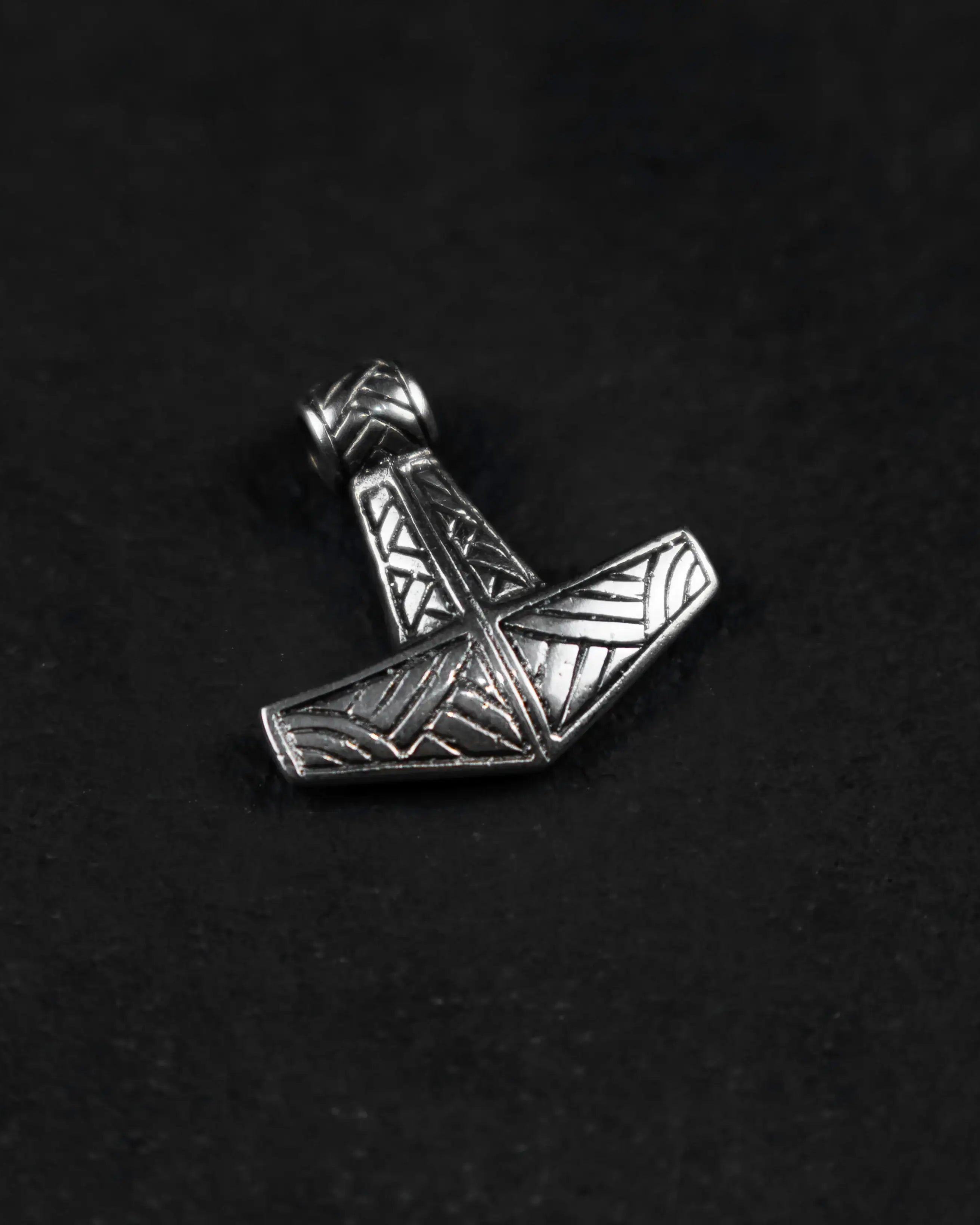 Silver Thor's Hammer pendant with Norse geometric engravings on black background