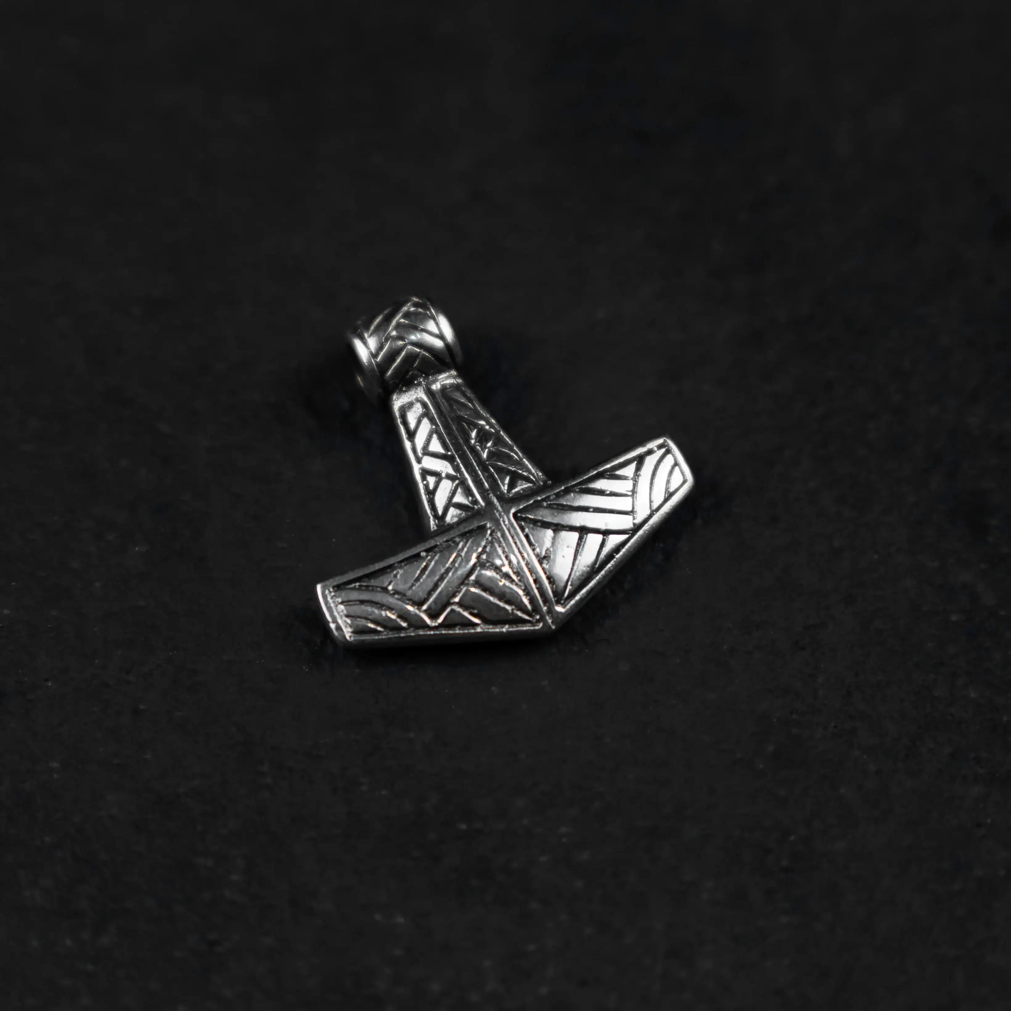 Silver Thor's Hammer pendant with Norse geometric engravings on black background