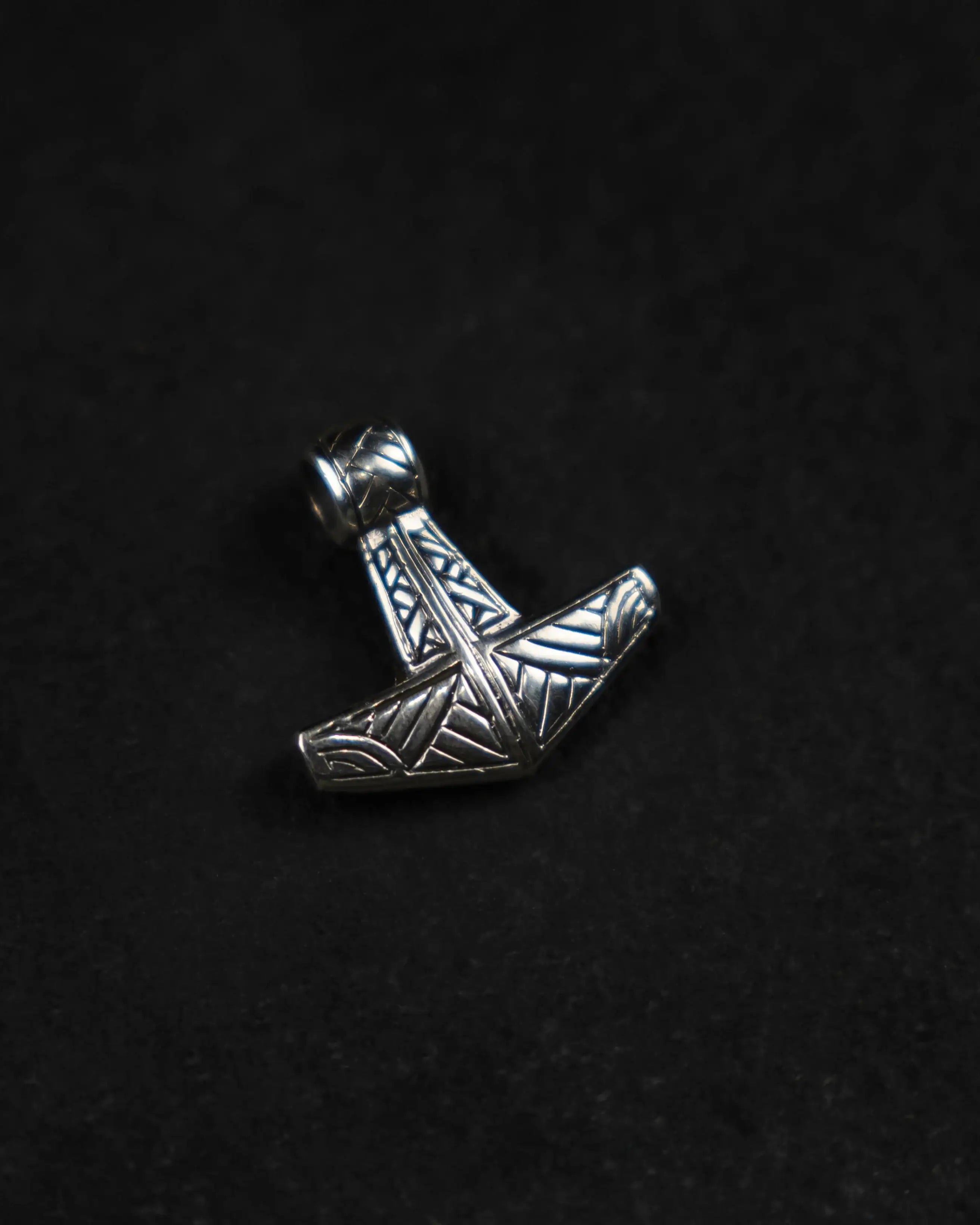 Silver Thor's hammer pendant with Norse knotwork, Viking jewelry on black background