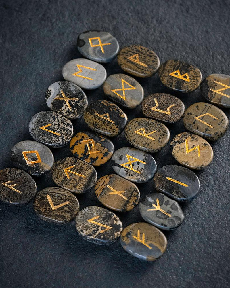 Norse runes engraved on stones with golden symbols, authentic Viking-inspired artifacts