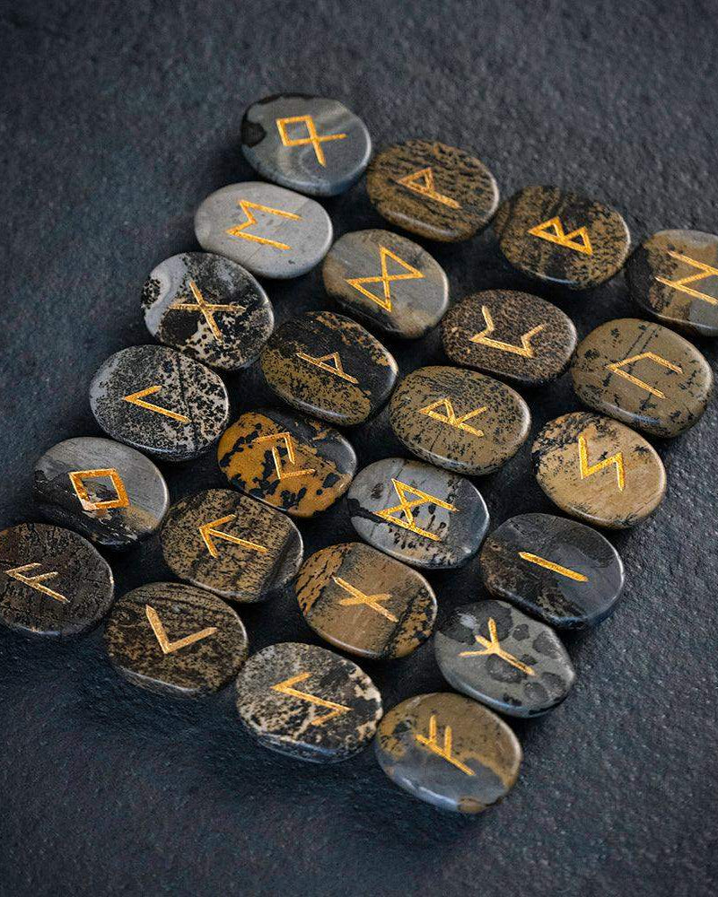 Norse runes engraved on stones with golden symbols, authentic Viking-inspired artifacts