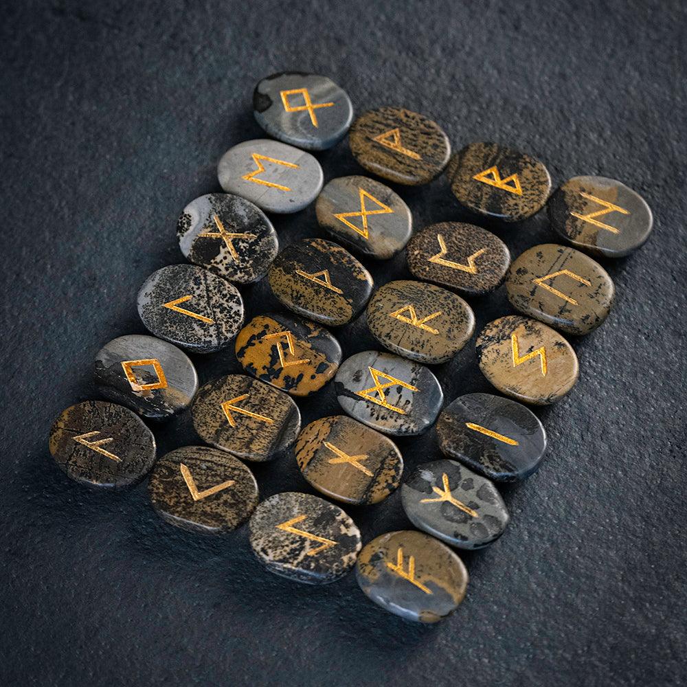 Norse runes engraved on stones with golden symbols, authentic Viking-inspired artifacts
