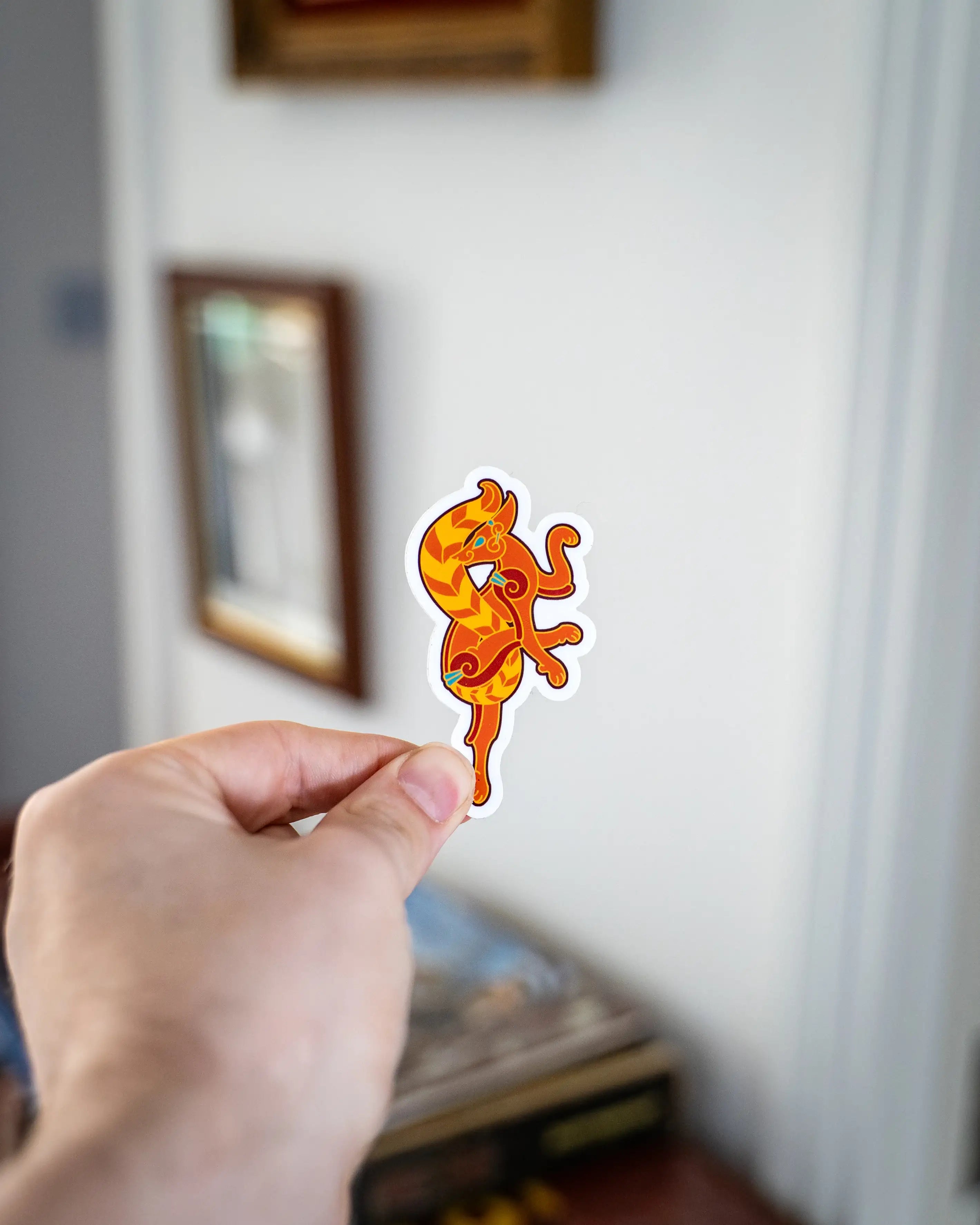 Viking dragon sticker with Norse art design, held in hand