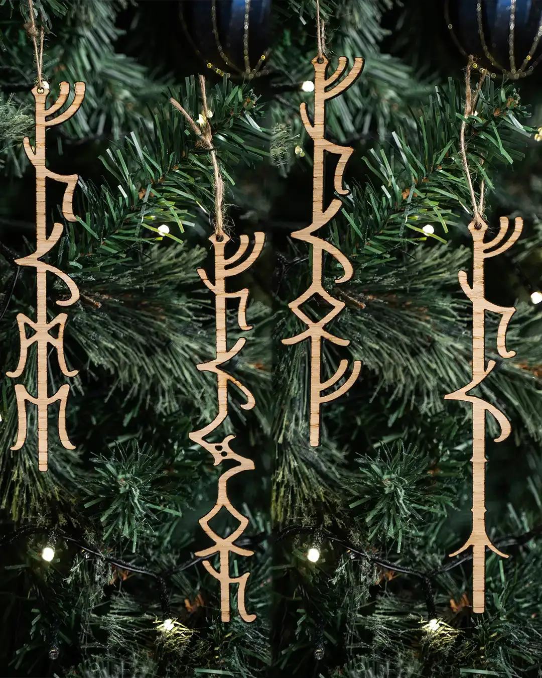Wooden Norse rune ornaments hanging on a Christmas tree with warm lights