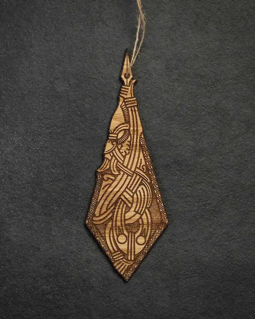 Laser-cut wooden pendant with intricate Norse knotwork and Viking-inspired design, hanging on twine against dark background