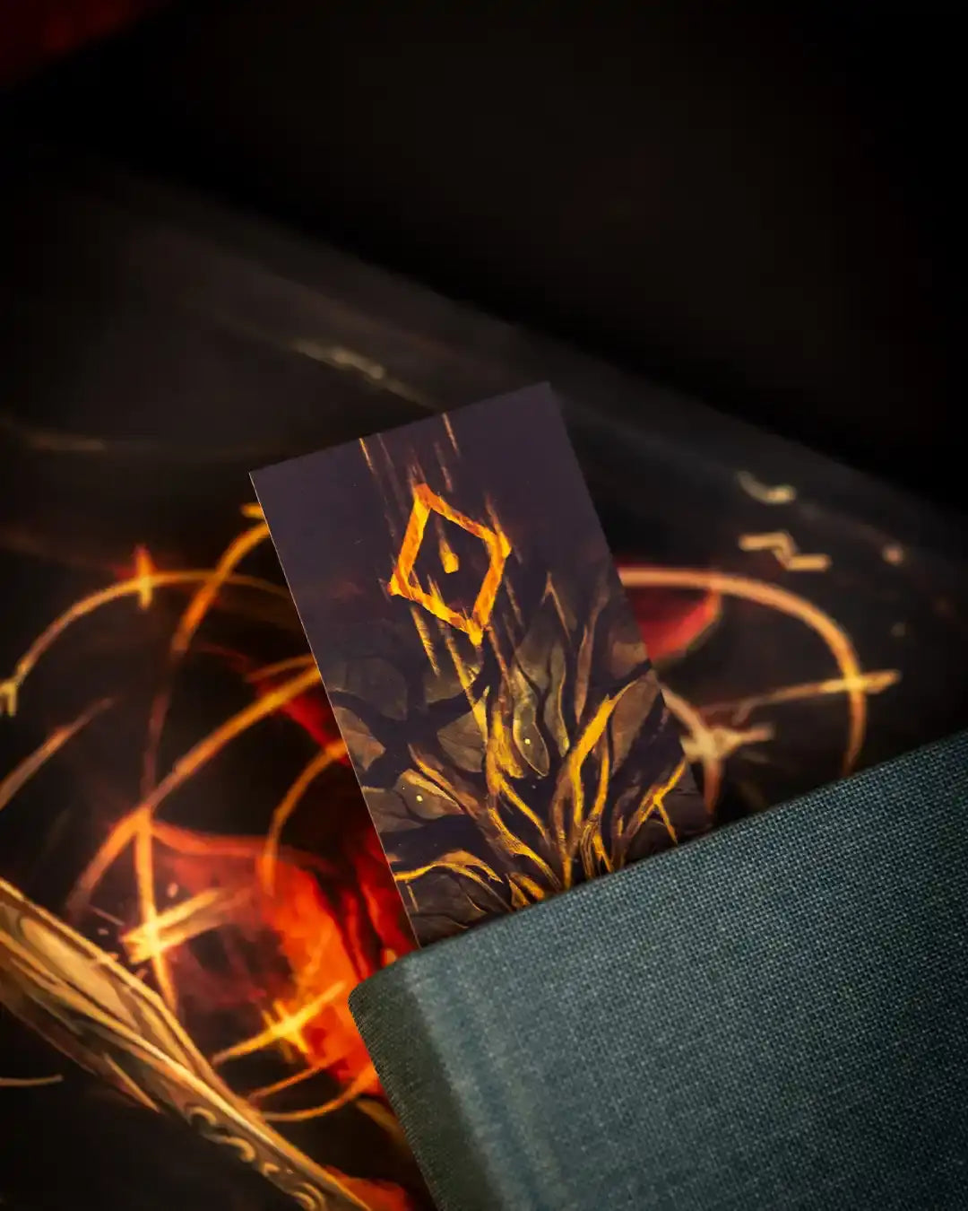 Norse-inspired art card with glowing rune design, resting on dark textured book cover