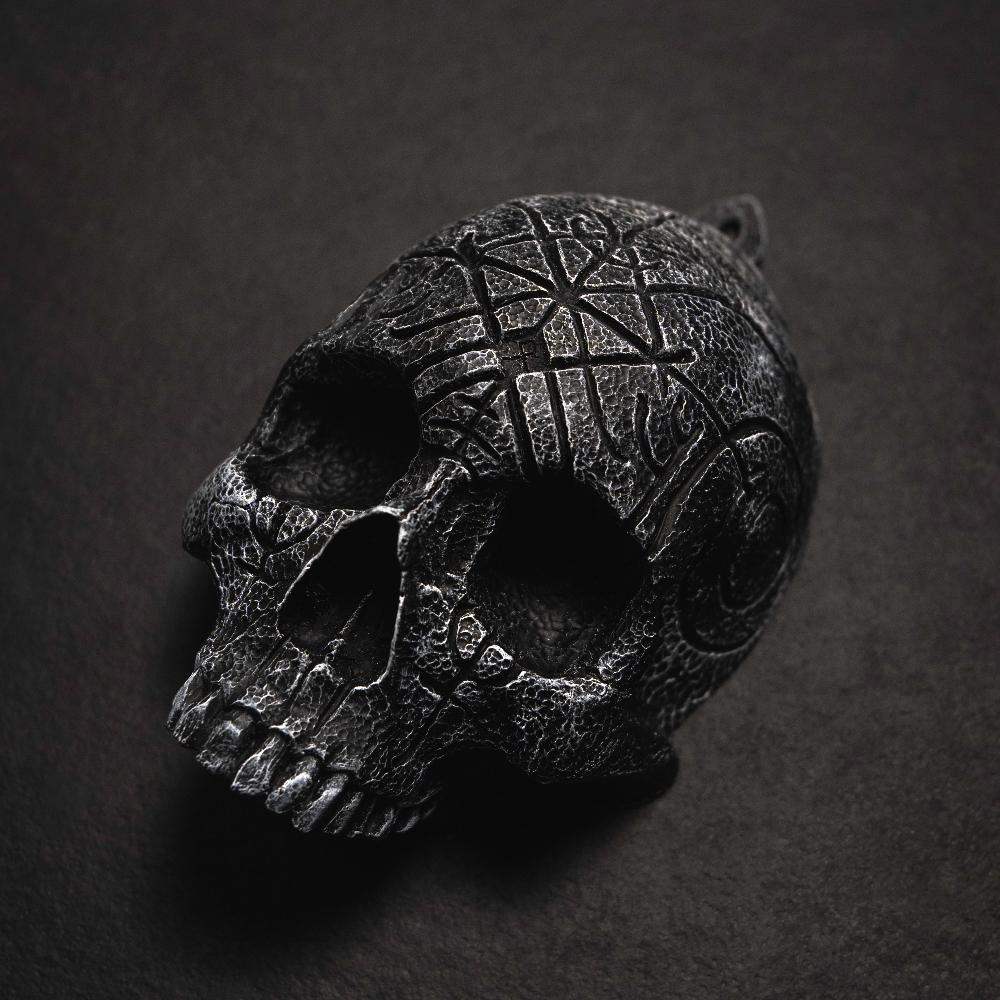 Dark skull pendant with Norse runes and Viking knotwork, textured black finish