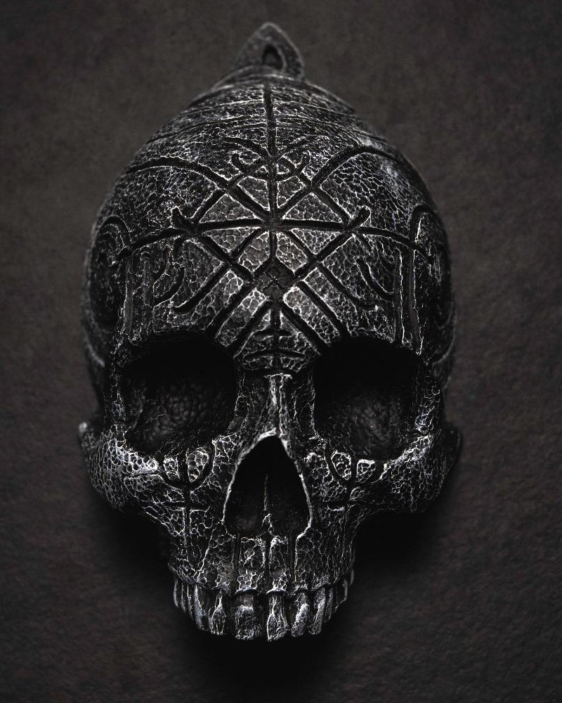 Depicting one of three skulls that are in a collection. They are resin human shaped skulls with runes on them, each representing one of the following: Love, Lust, Loss.