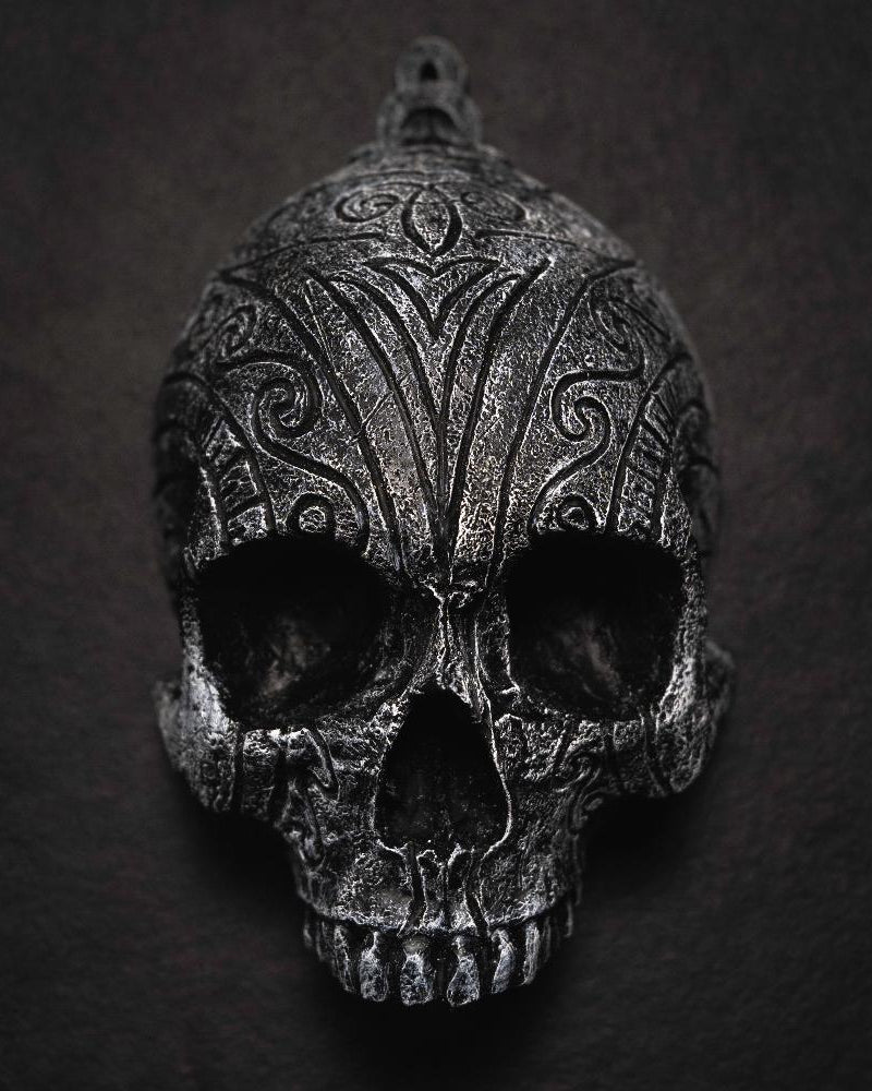 Depicting one of three skulls that are in a collection. They are resin human shaped skulls with runes on them, each representing one of the following: Love, Lust, Loss.