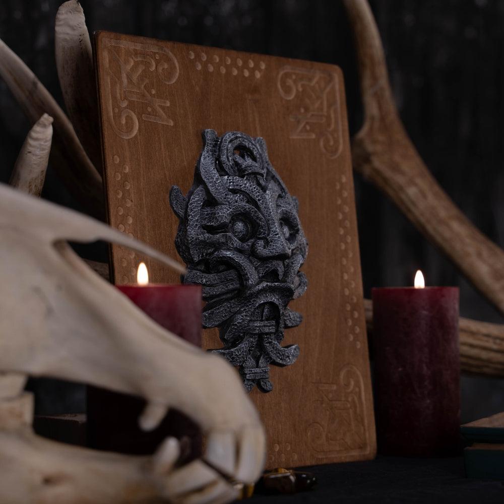 Viking-inspired dragon mask wall art with Norse runes, displayed on wooden plaque with antlers and candles
