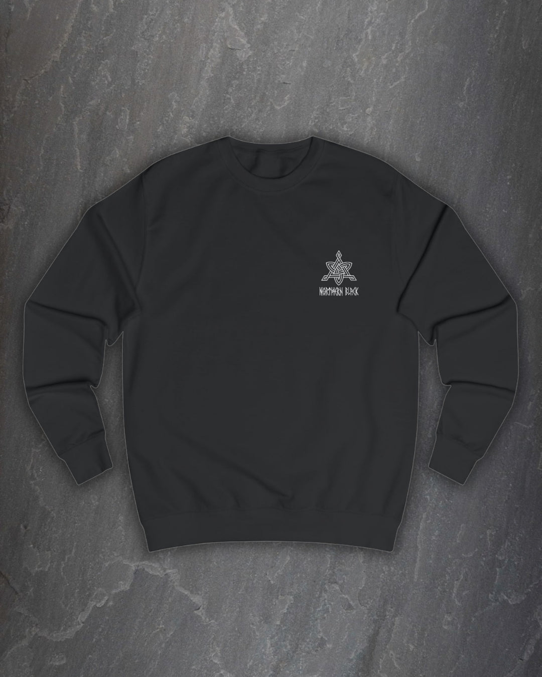 Front of a black Odin Godmask sweatshirt with a small Northern Black logo on the chest on a dark slate background