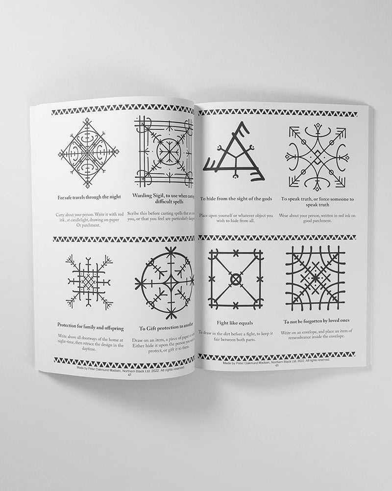 Norse rune symbols and Viking tattoo designs from authentic historical sources, shown in an open art book.