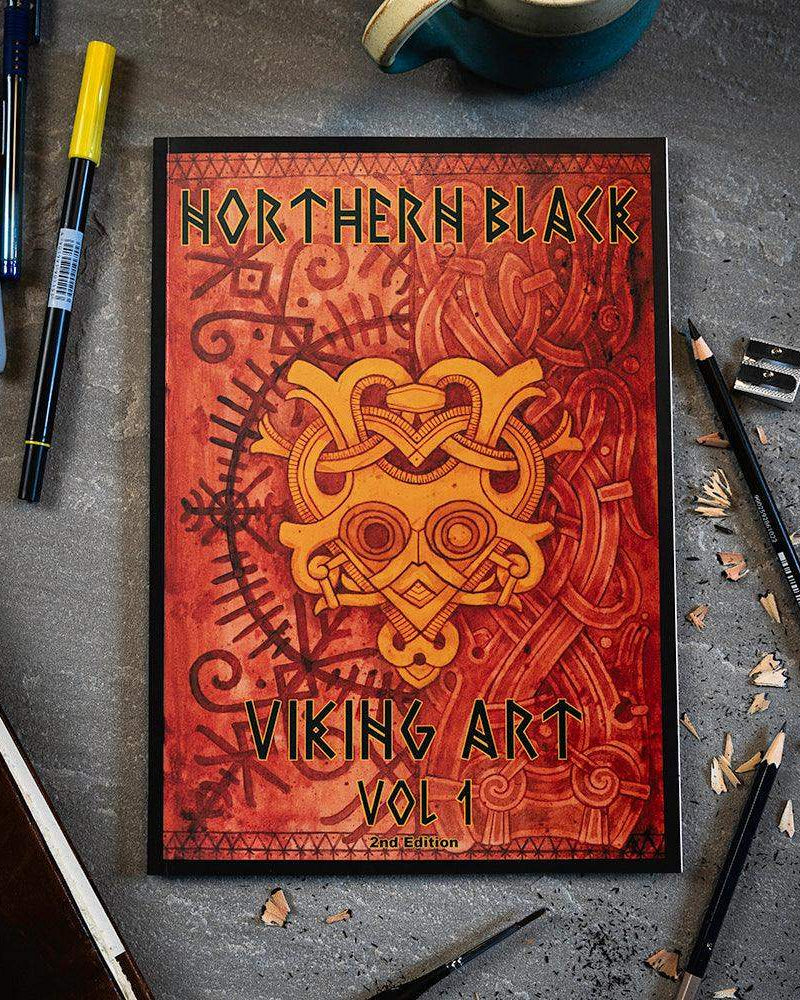 Northern Black Viking Art Vol 1 book with Norse knotwork design, surrounded by drawing tools on concrete