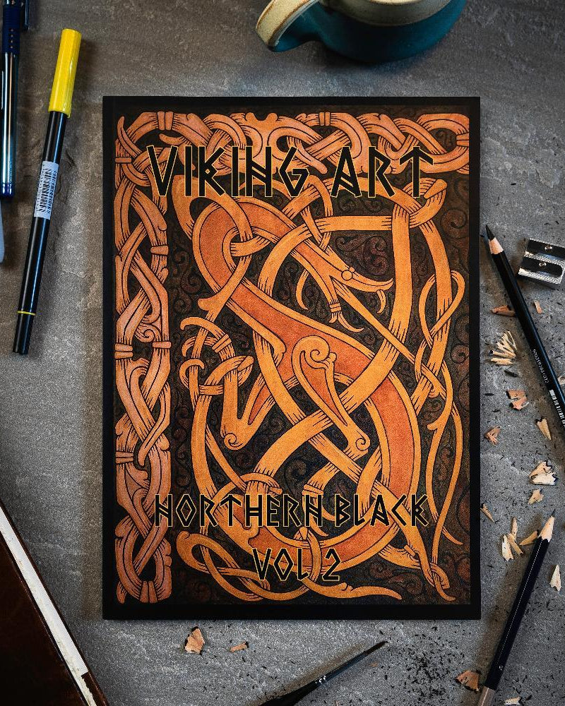 Viking Art Northern Black Vol 2 book with Norse knotwork design, surrounded by pens and pencils on gray surface