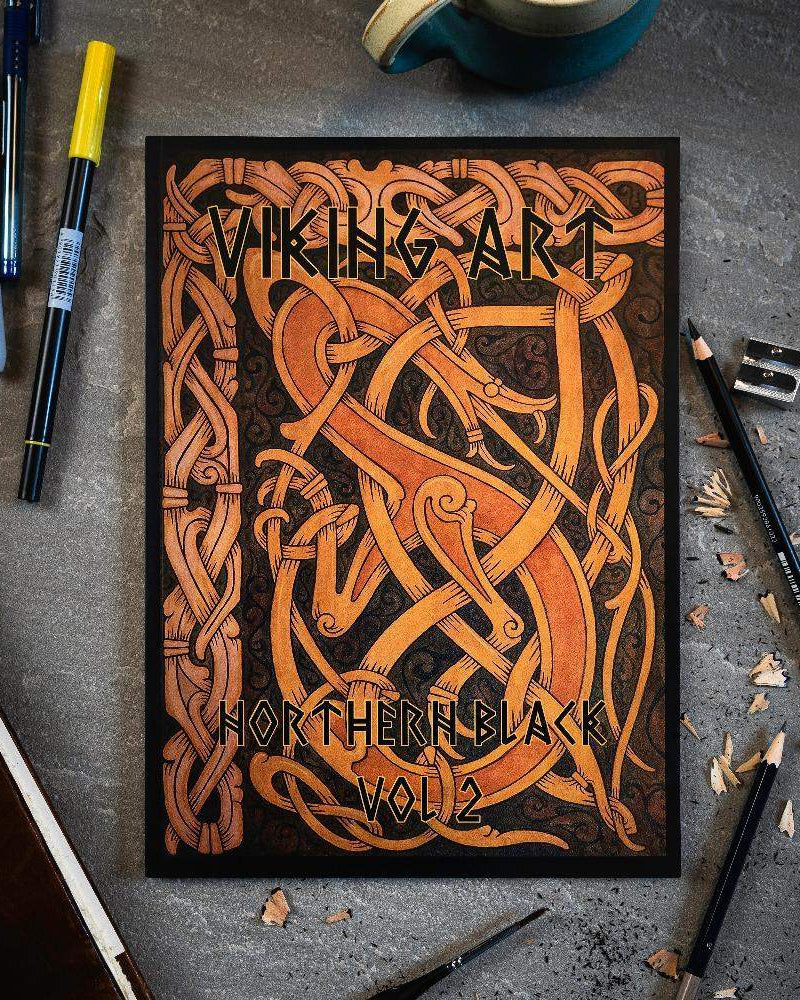 Viking Art Northern Black Vol 2 book with Norse knotwork design, surrounded by pens and pencils on gray surface