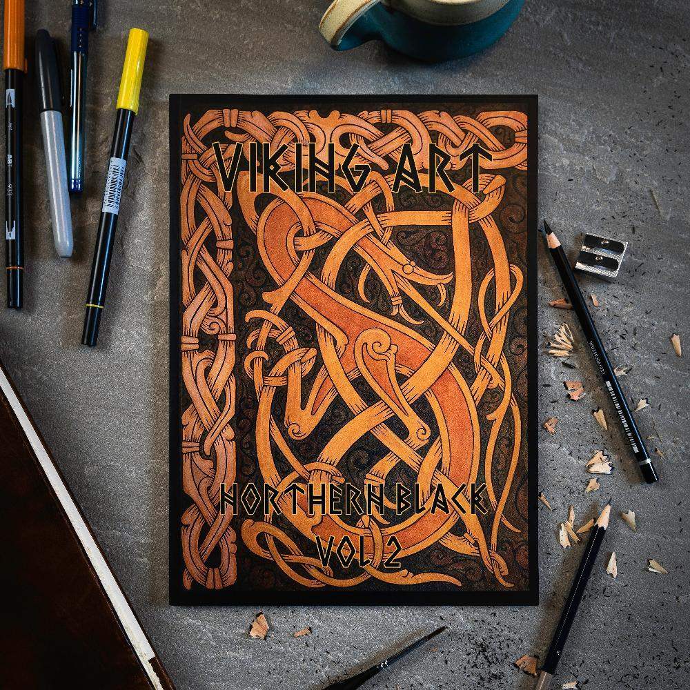 Viking Art Northern Black Vol 2 book with Norse knotwork design, surrounded by pens and pencils on gray surface