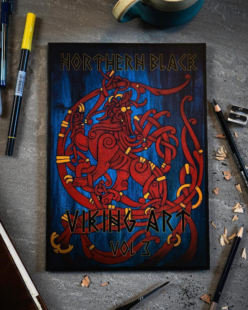 Northern Black Viking Art Vol 3 book with red Norse dragon design, surrounded by pens and pencils on gray surface