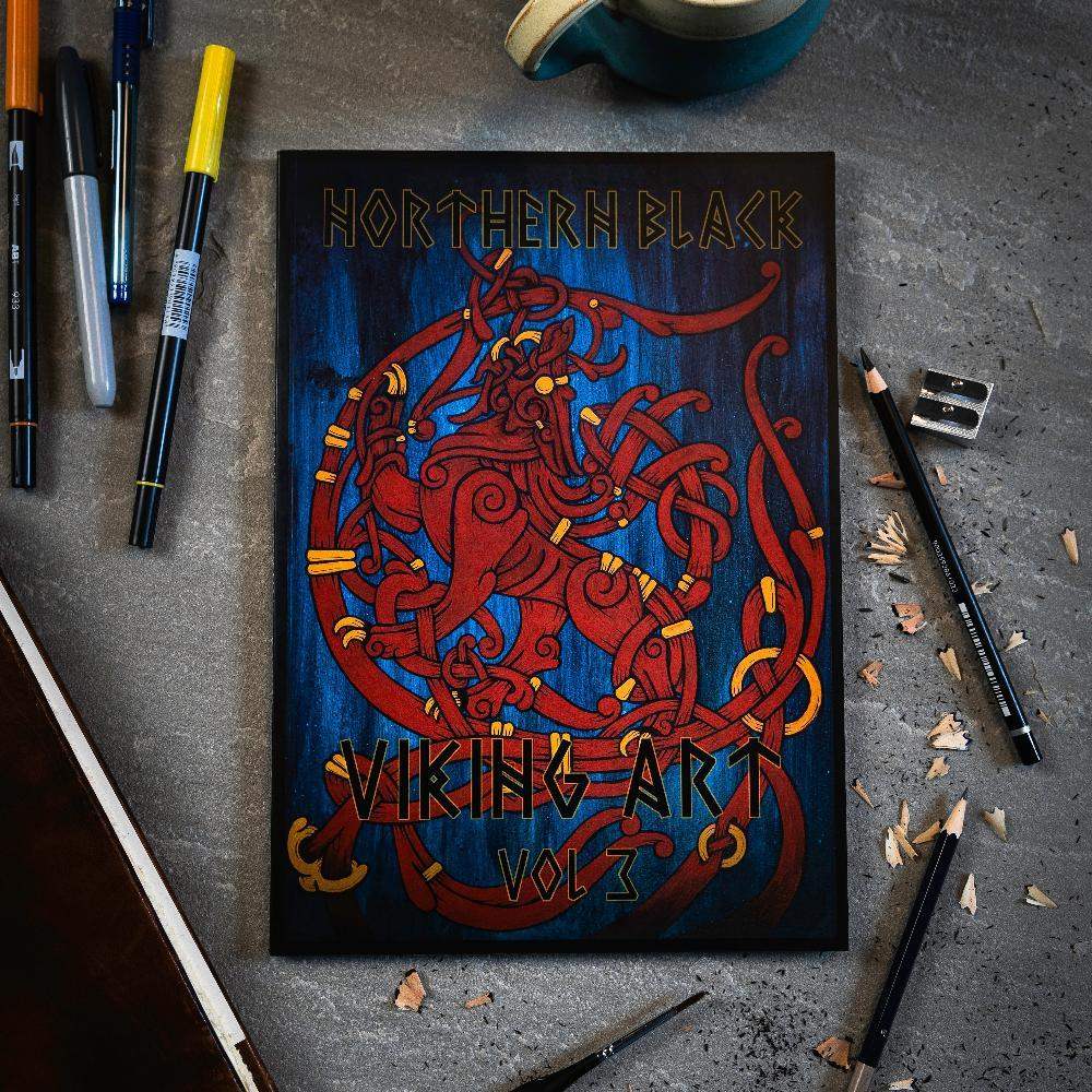 Northern Black Viking Art Vol 3 book with red Norse dragon design, surrounded by pens and pencils on gray surface