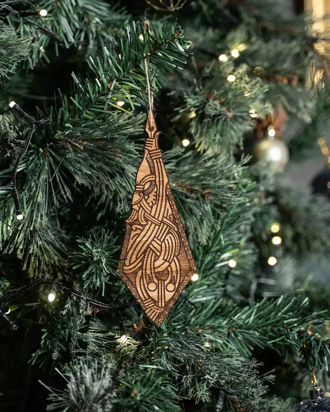 Wooden Viking ornament with Norse knotwork hanging on Christmas tree, featuring authentic runic design