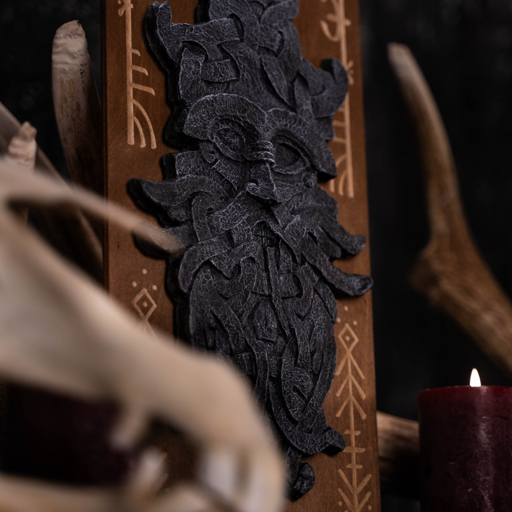 stonelike godmask of odin, put on a engraved wooden background with runes