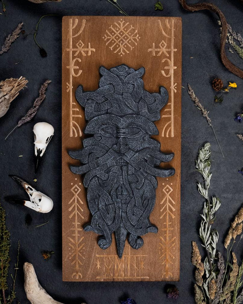stonelike godmask of odin, put on a engraved wooden background with runes