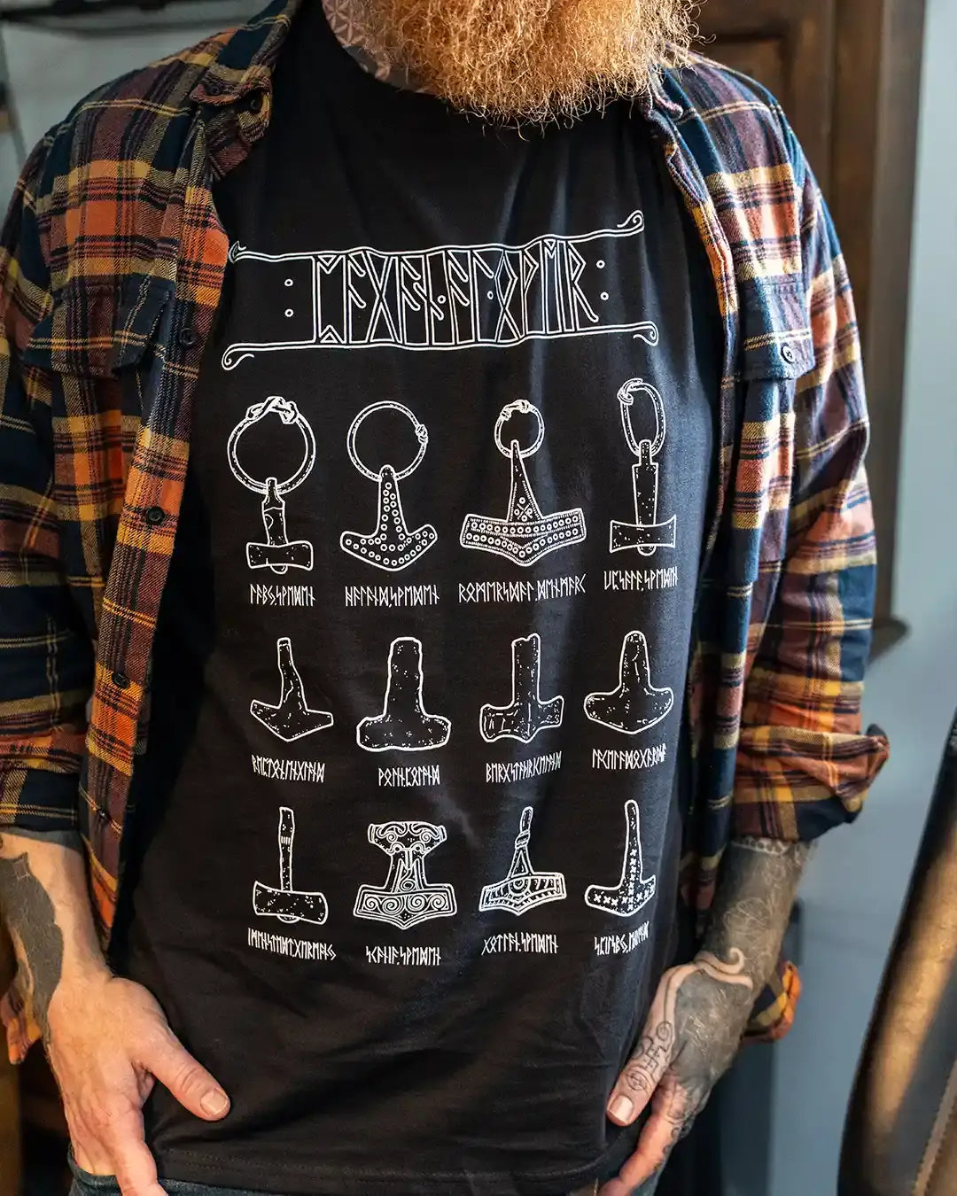 Black t-shirt with Norse Mjolnir hammer designs and runes, worn under plaid shirt