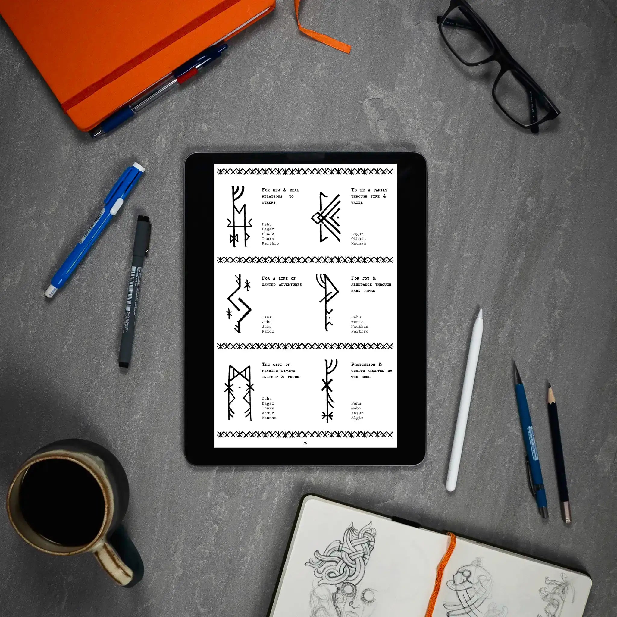 Viking rune designs on tablet with Norse tattoo art, sketchbook, and coffee — authentic Norse-inspired symbols