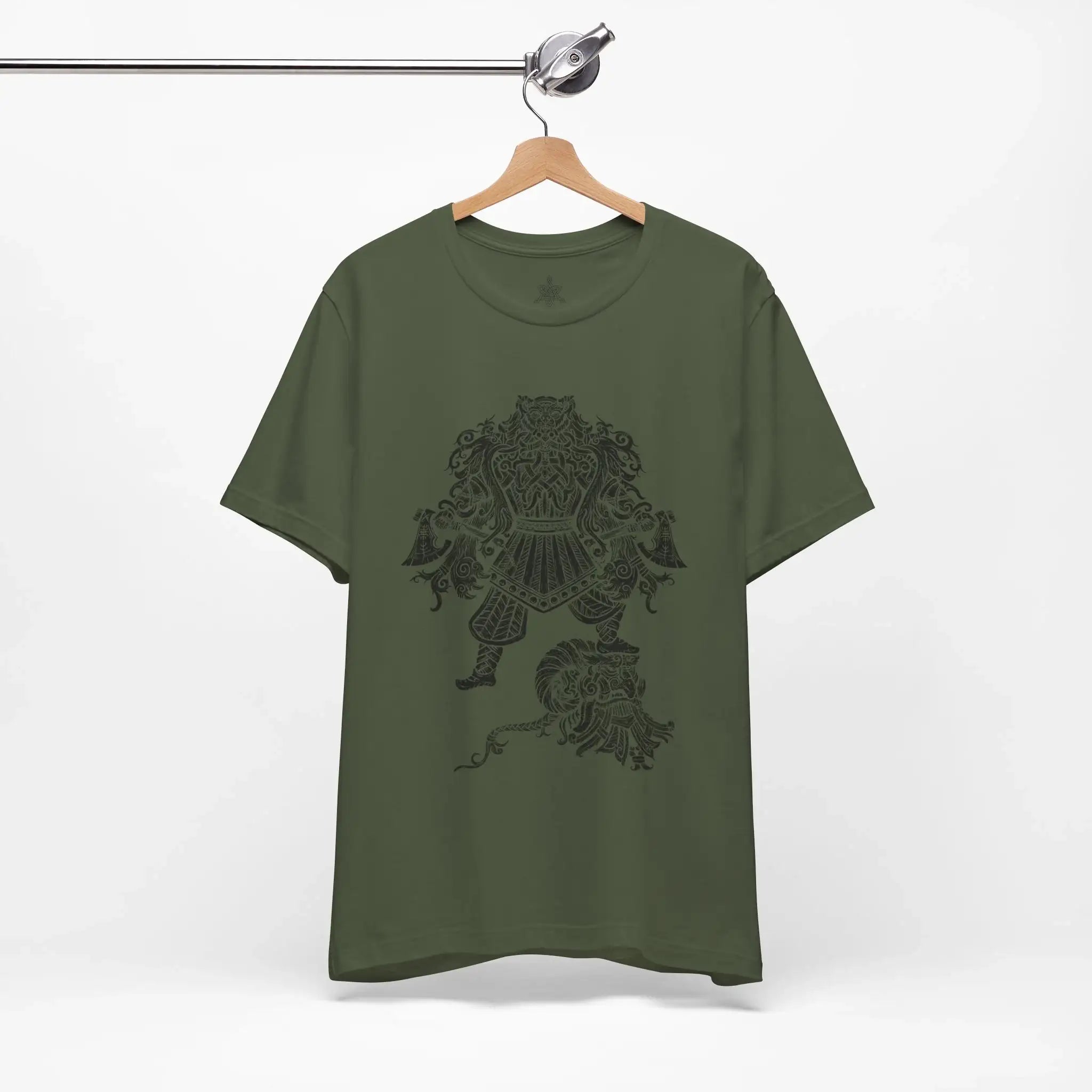 An olive green short-sleeve t-shirt hanging on a wooden hanger from a metal clothing rack, featuring a dark graphic print of a Viking Berserker on the front.