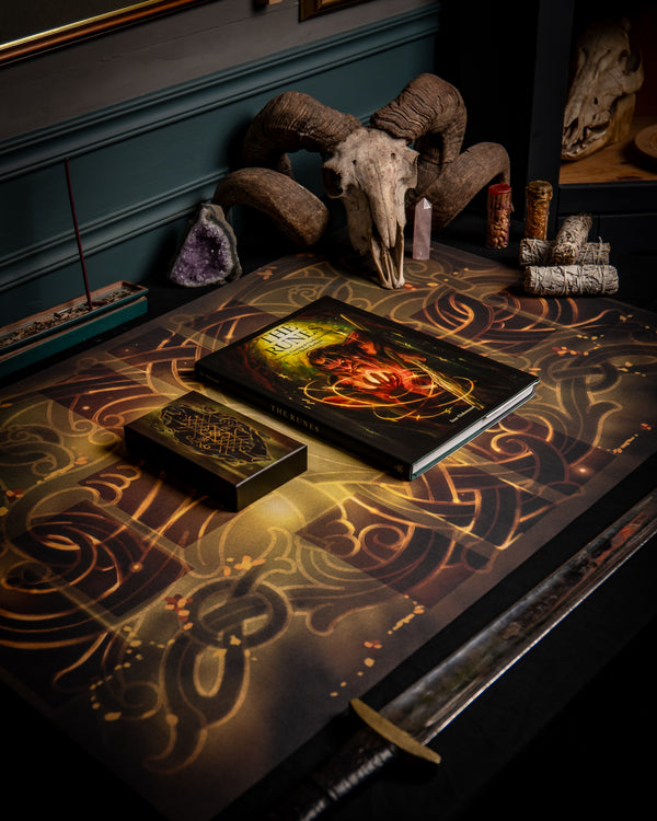 Norse-inspired book 'The Runes' on ornate table with ram skull, crystals, and Viking sword