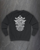 Back of a black Odin Godmask sweatshirt with a large white Norse knotwork Odin mask print on a dark slate background