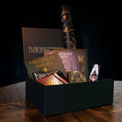 Norse-inspired gift box with runes, sigils, bindrunes books, art prints, and Viking-themed items on dark wood